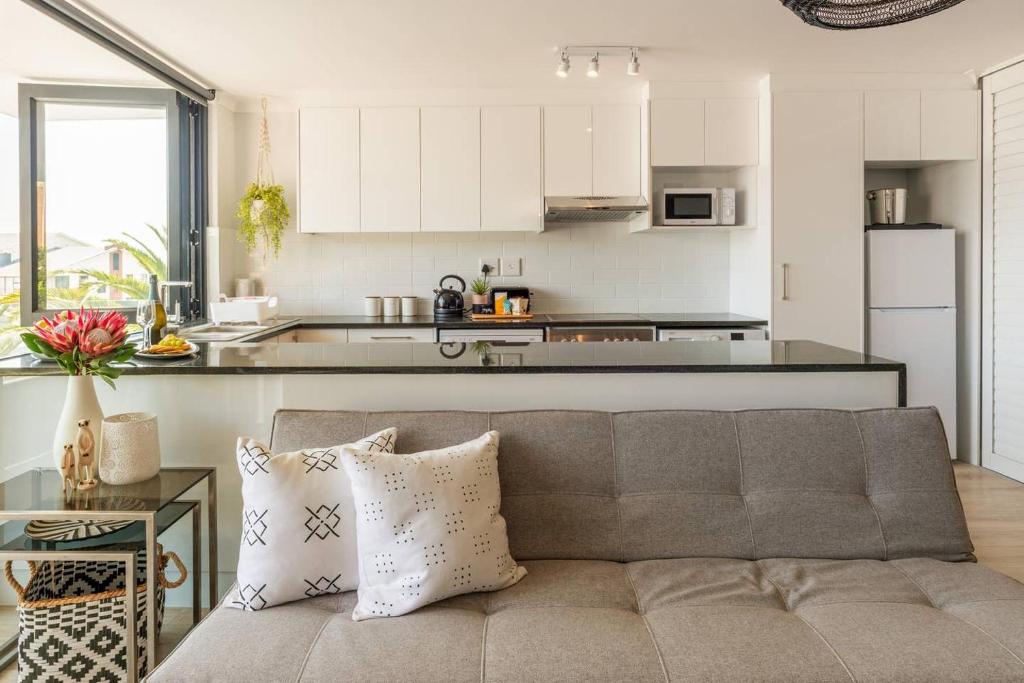 sala de estar con sofá y cocina en MONDAINE CENTRAL LUXURIOUS SPACIOUS AND TRENDY, en Ciudad del Cabo