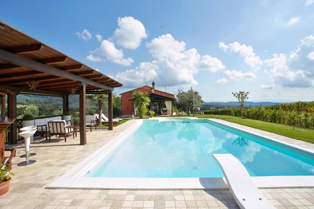 una piscina con patio e una casa di Holiday home with exclusive swimming pool in the Tuscan Maremma a Montemassi