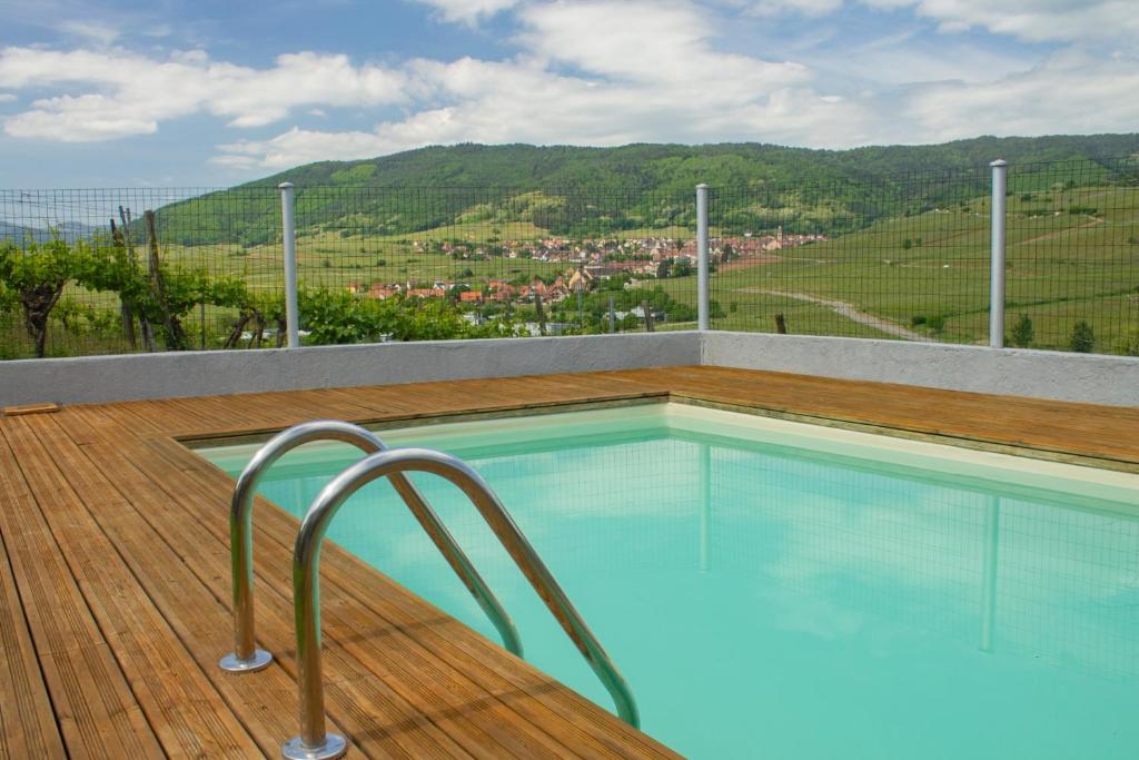 a swimming pool on a wooden deck with a view at Le Zell in Zellenberg