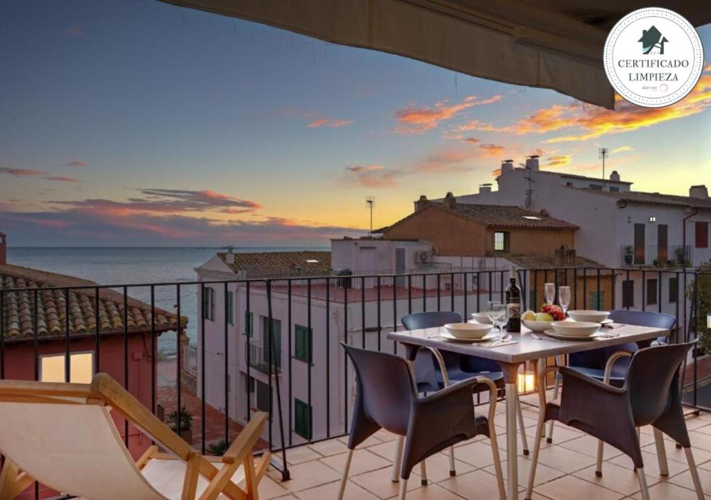 een tafel en stoelen op een balkon met uitzicht op de oceaan bij Canadell 2º 2ª in Palafrugell