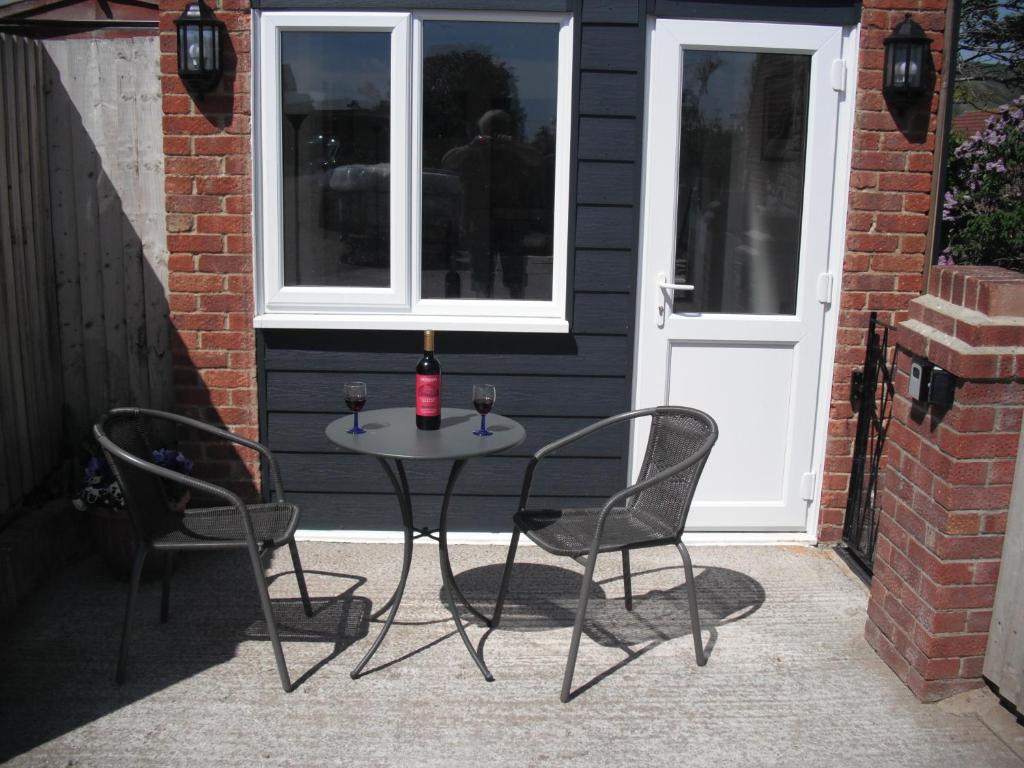 una mesa con 2 sillas y una botella de vino en White Horse Studio en Preston