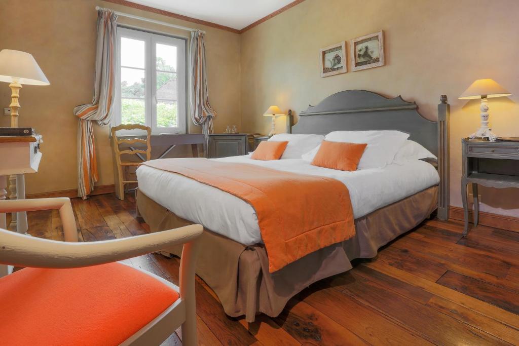 - une chambre avec un grand lit et une couverture orange dans l'établissement Le Pont de L'Ouysse, à Lacave
