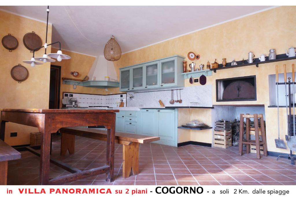 kuchnia z niebieskimi szafkami i drewnianym stołem w obiekcie Appartamento A in villa con vista panoramica w mieście San Salvatore