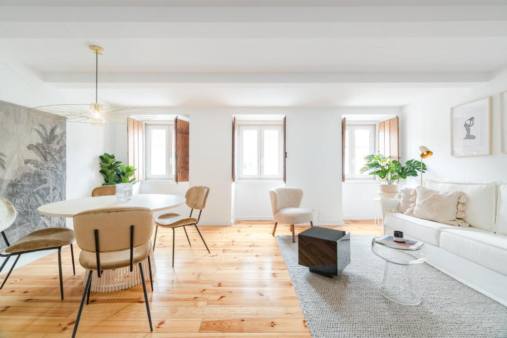een witte woonkamer met een witte bank en een tafel bij Casa Boma Lisboa - Charming and Typical Apartment - Lapa III in Lissabon