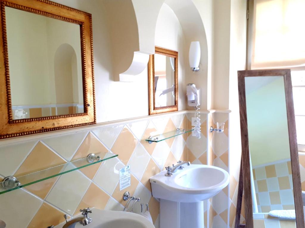 a bathroom with a sink and a toilet and a mirror at Hotel Villa Catarie in Guéthary