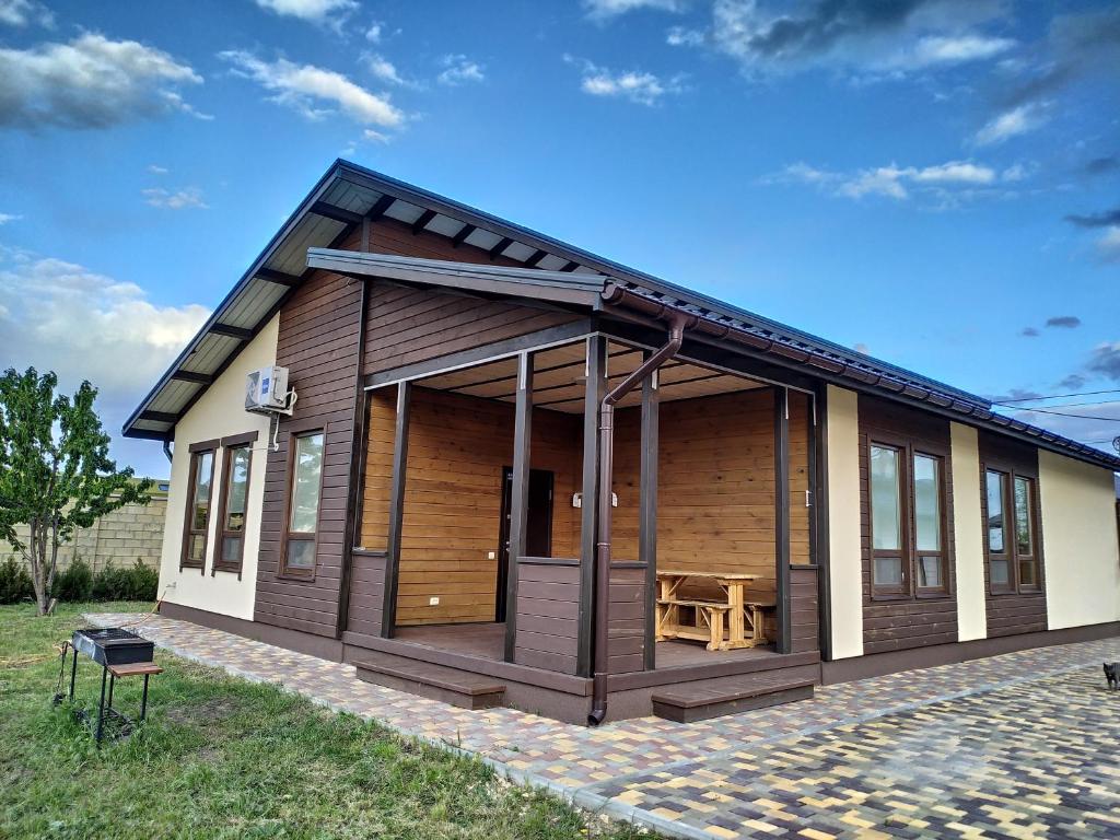 a small wooden house with a picnic table at Дом Дискавери на 10 человек у моря! in Chornomorsk