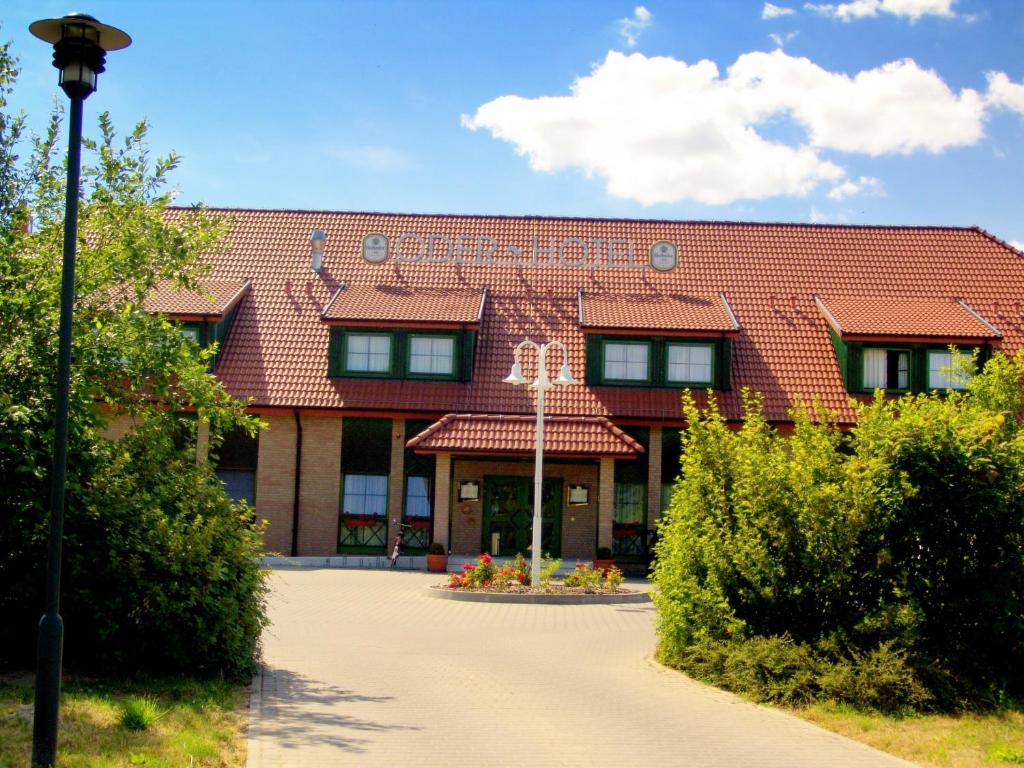 a large red brick building with a red roof at Oder-Hotel in Schwedt
