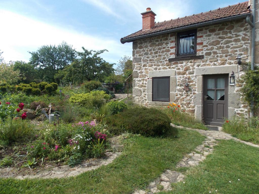 uma casa de pedra com um jardim em frente em côté jardin em Saint-Clément