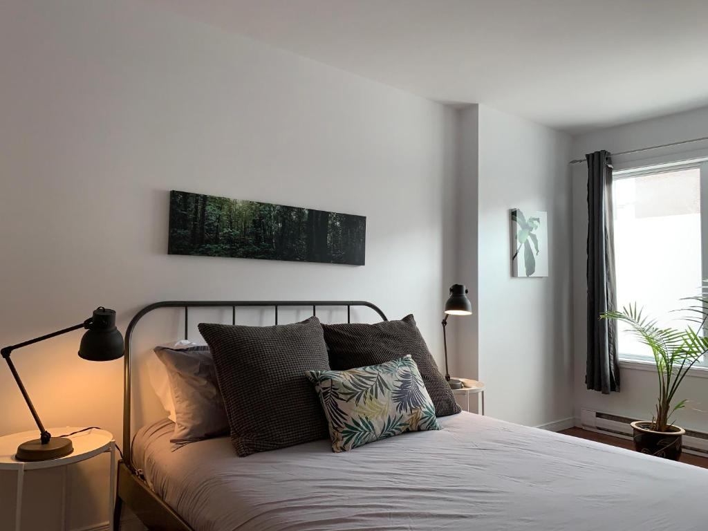 Hotel Le 315B Limoilou "parking inclus", a bedroom with a bed with pillows and a window at Le 315B Limoilou "parking inclus" in Quebec City