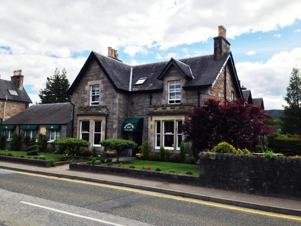 una casa vieja al lado de la carretera en Buttonboss Lodge B&B, en Pitlochry