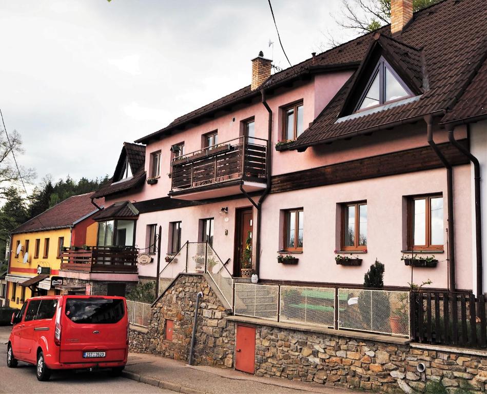 捷克克魯姆洛夫的住宿－亞當公寓式酒店，停在房子前面的一辆红色面包车