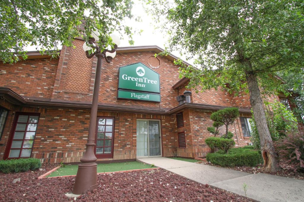 un edificio in mattoni con un cartello per una locanda per corni verdi di GreenTree Inn Flagstaff a Flagstaff