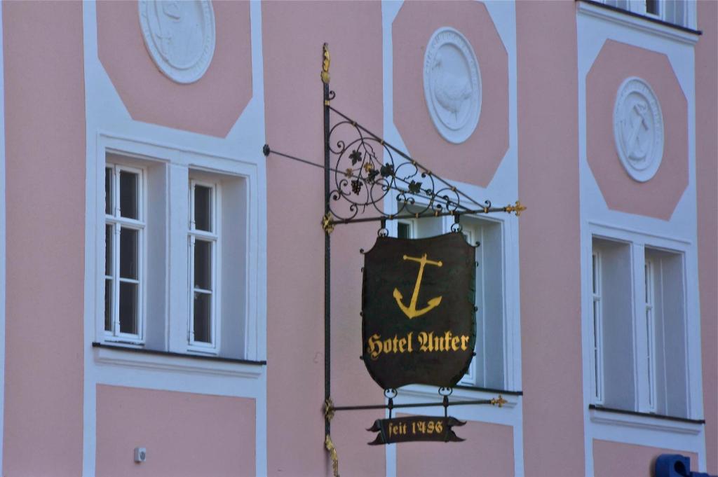a pink building with a clock on the side of it at Hotel Anker in Saalfeld