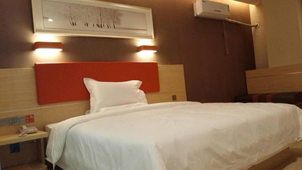 een slaapkamer met een groot wit bed in een kamer bij 7Days Premium Tangshan Fengnan Shuang Lake Jinyuan in Tangshan