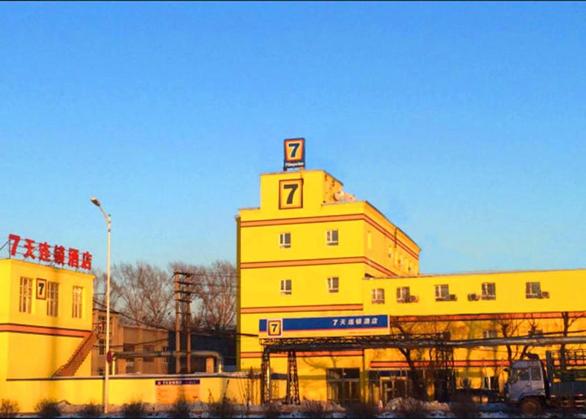 7Days Inn Harbin Pioneer Road Xilong Market في هاربين: مبنى اصفر وعليه لوحه