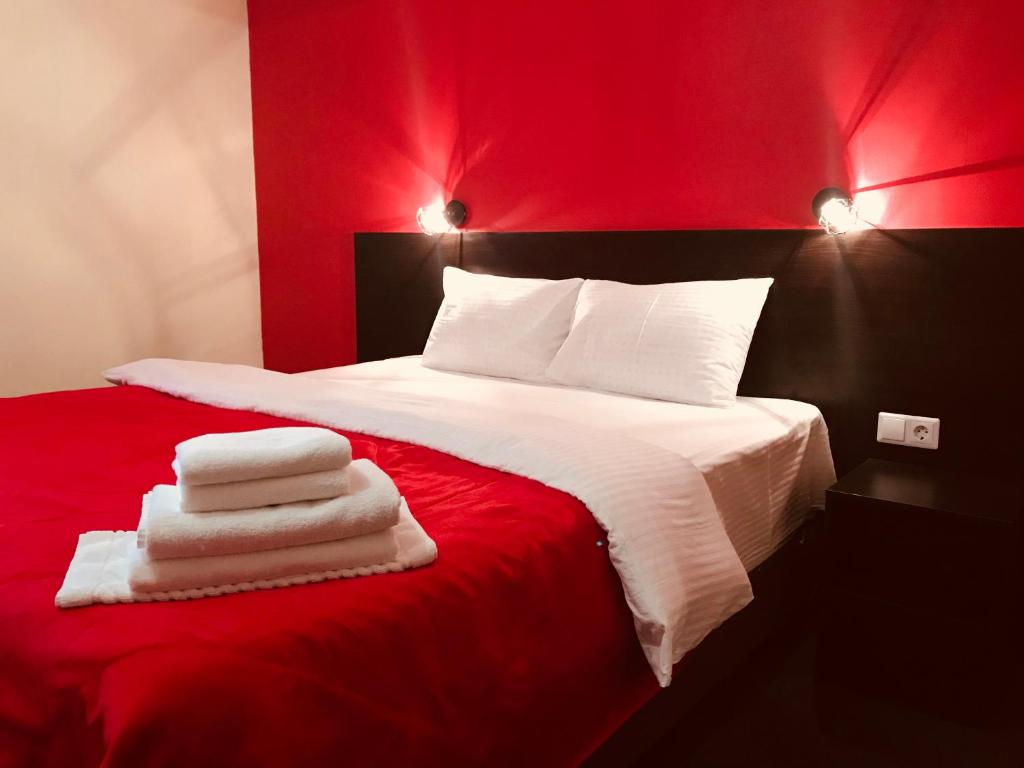 a red bedroom with a bed with towels on it at Hotel Diamant Borsheva in Bronnitsy