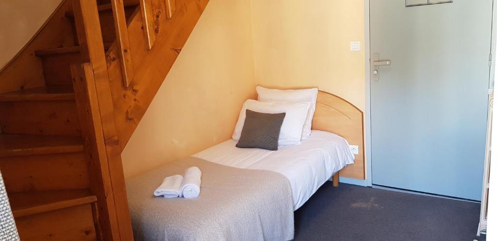 a small room with a bed with white shoes on it at Hôtel Terminus in Luz-Saint-Sauveur
