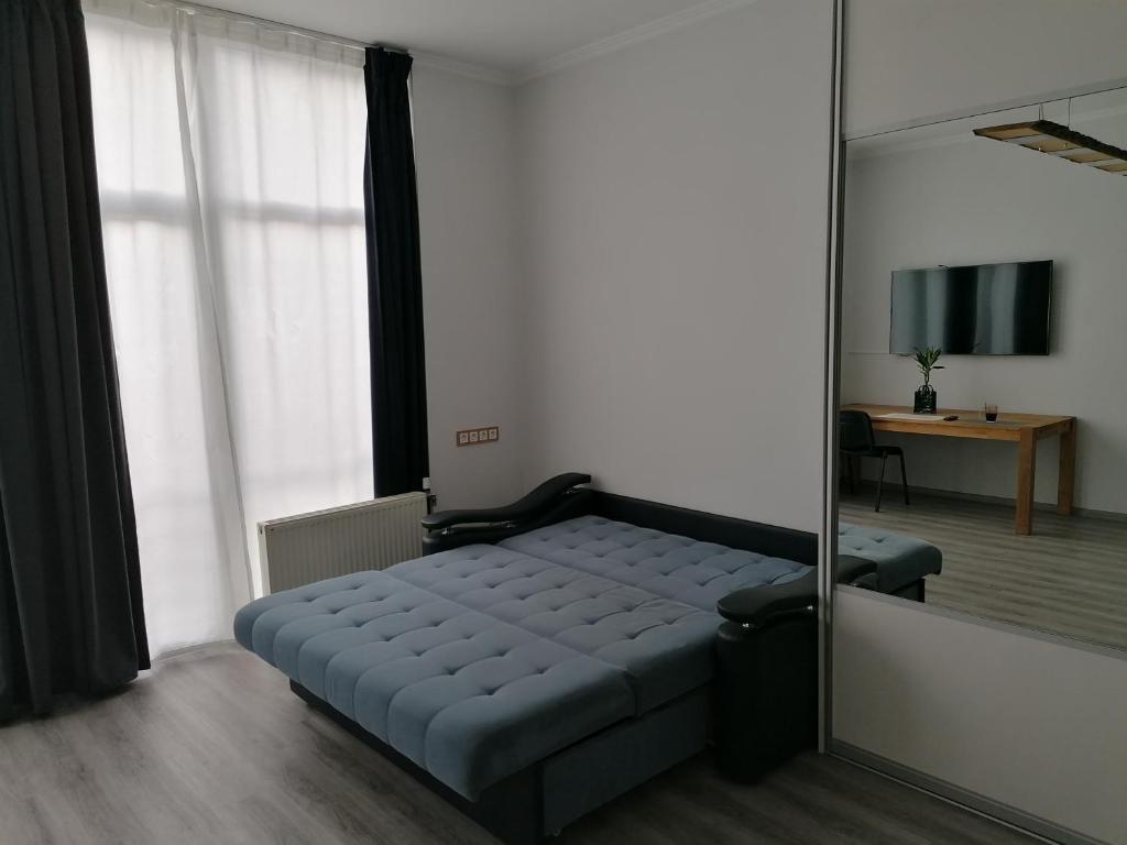 a bed in a room with a mirror at Palm apartment studio Riga in Rīga