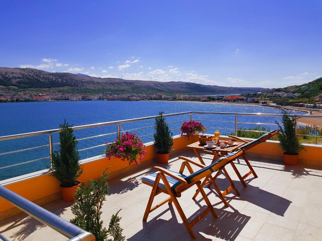 a balcony with a table and chairs and a view of the water at Boutique Villa Revelin in Pag