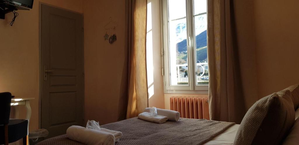 a bedroom with a window with towels on a bed at Hôtel Terminus in Luz-Saint-Sauveur