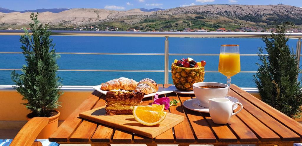 una mesa con comida y un vaso de zumo de naranja en Boutique Villa Revelin en Pag