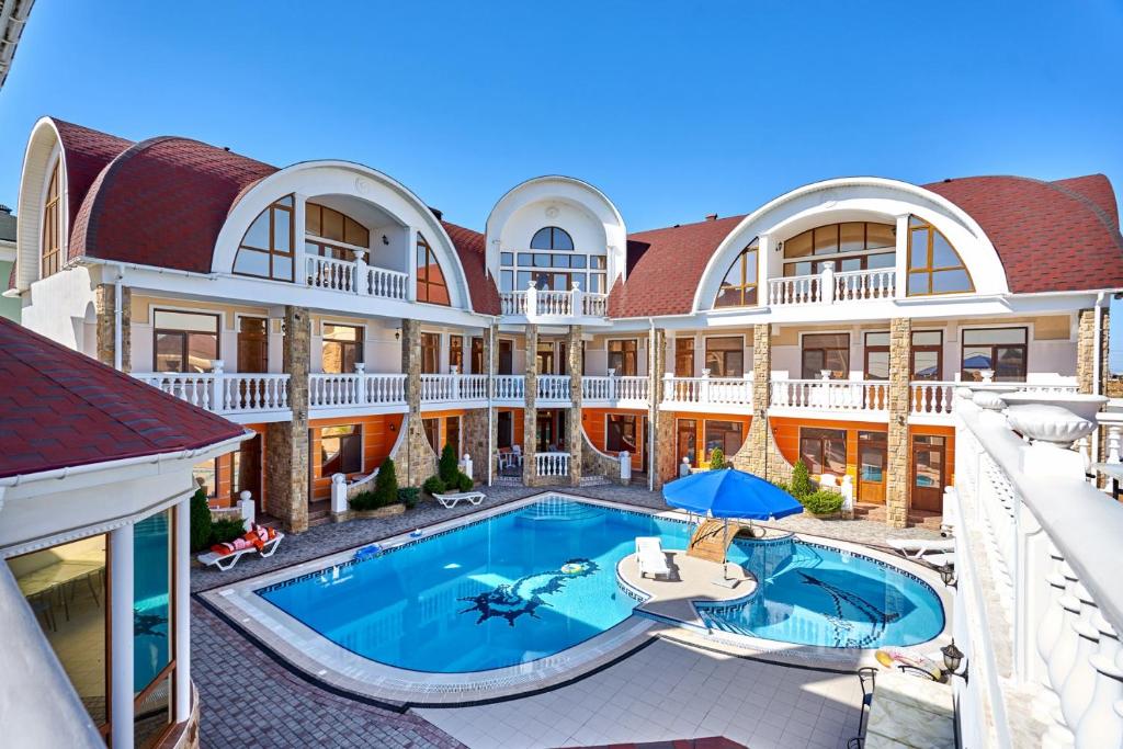 una vista exterior de una casa grande con piscina en Гостевой дом Лев, en Eupatoria