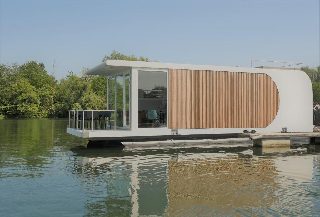 a house on a dock on a body of water at Houseboat Martinique in Maastricht