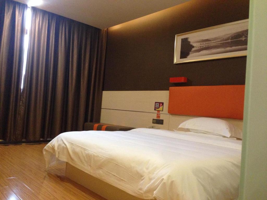 a bedroom with a white bed and a window at 7Days Premium Yunfu Xinxing Bus Station in Yunfu