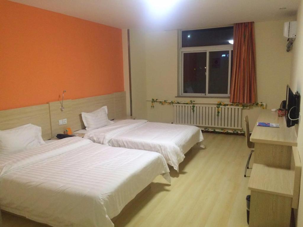 A bed or beds in a room at 7Days Inn Yantai Development Zone Beach