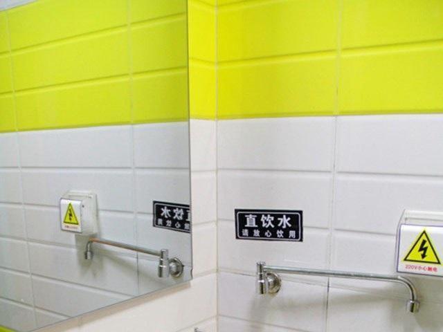 - une salle de bains avec des murs jaunes et blancs et des panneaux sur le mur dans l'établissement 7Days Inn Huaibei Zhongtai Plaza Wanda Studios, à Huaibei
