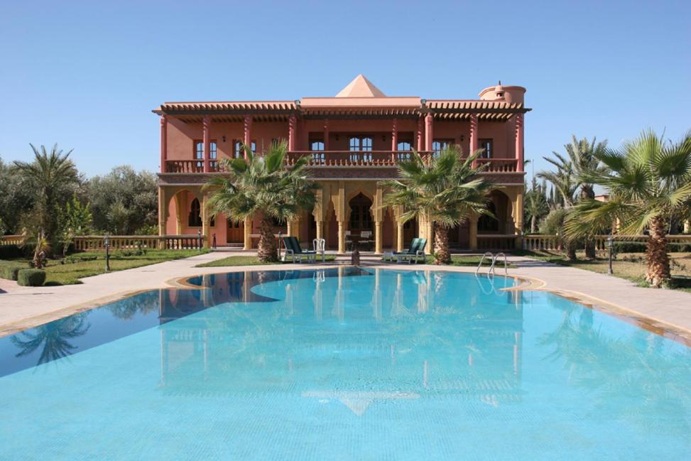 a large swimming pool in front of a house at Villa Zahra Palmeraie in Marrakesh