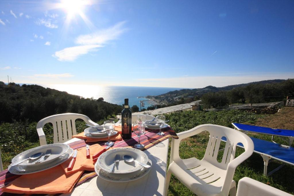 una mesa de picnic con una botella de vino y sillas en Il Giardino Sul Mare, en Imperia