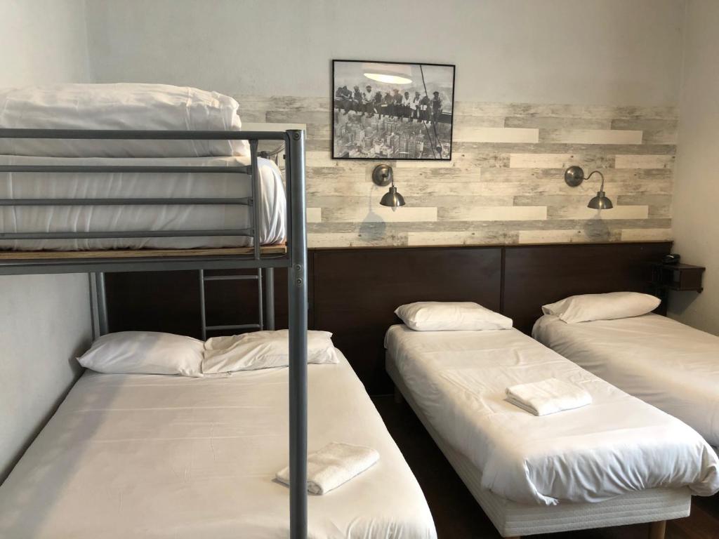 a room with three bunk beds in it at Hôtel des Ambassadeurs in Toulouse