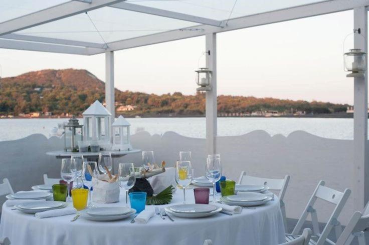 a white table with plates and glasses on it at Mari del Sud Resort in Vulcano
