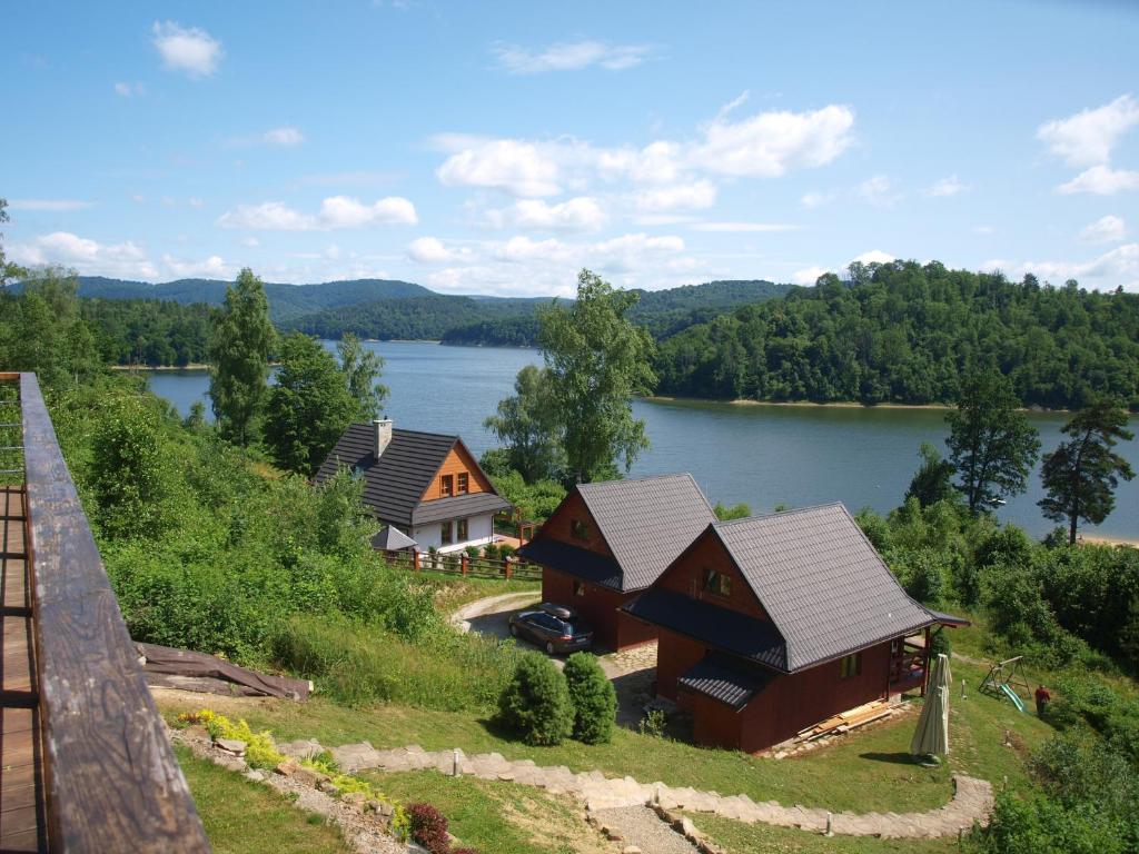 an aerial view of a house on a hill next to a lake at Świerkowe Chatki - Apartament Kominkowy in Olchowiec