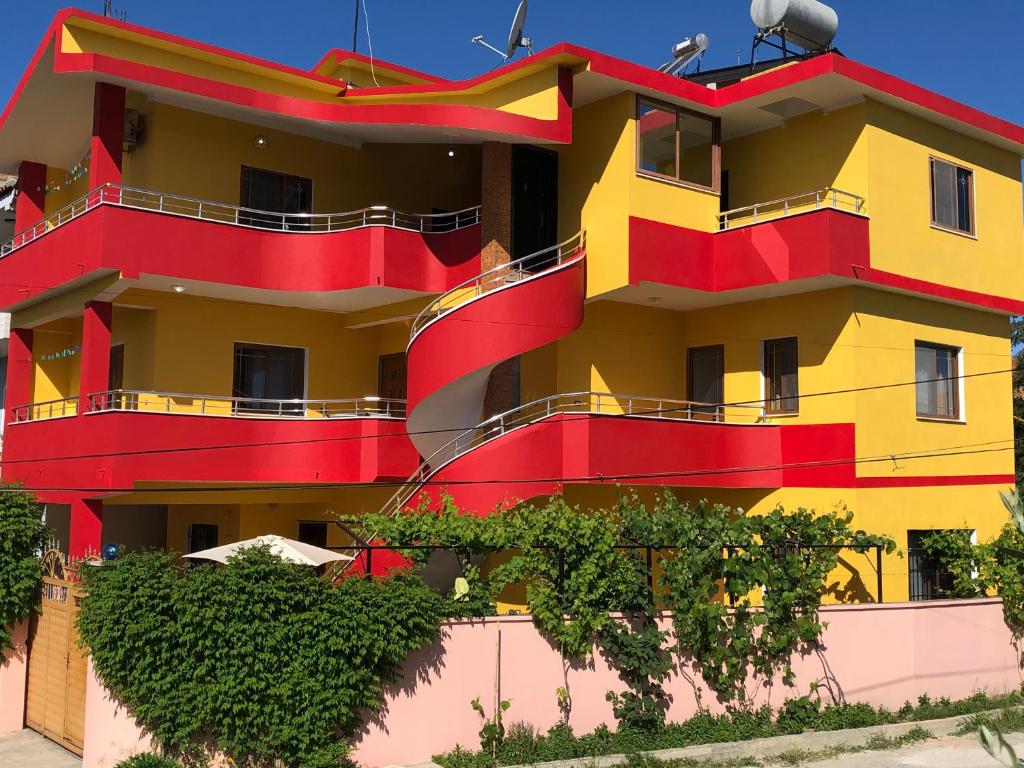 um edifício colorido com varandas vermelhas e amarelas em Guest House MURATI em Durrës
