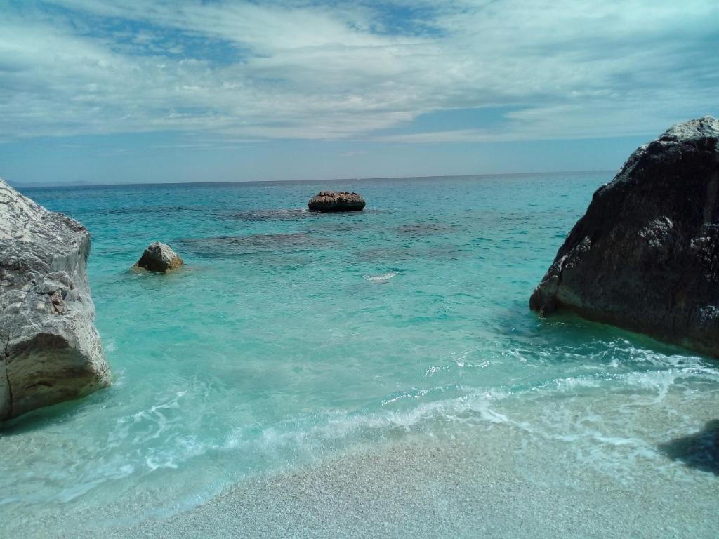 a beach with two large rocks in the water at casa delle mimose in Cardedu