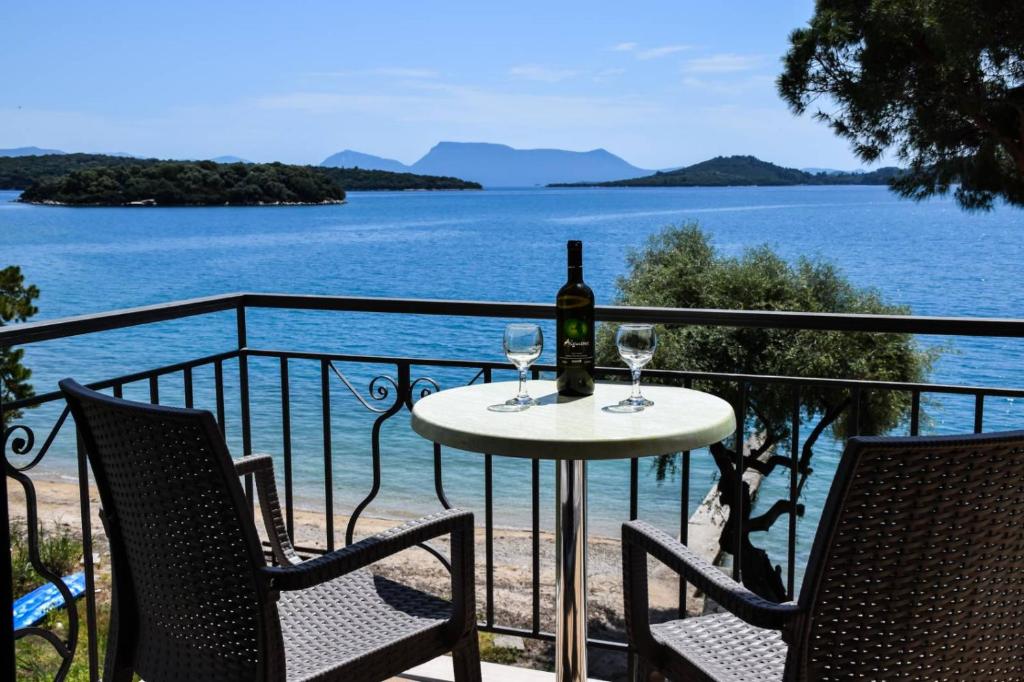 a table with a bottle of wine and two glasses at Marina Pansion in Nydri