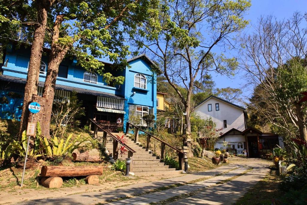 a blue house with stairs in front of a house at Xiangyang Tianyuan in Sanyi
