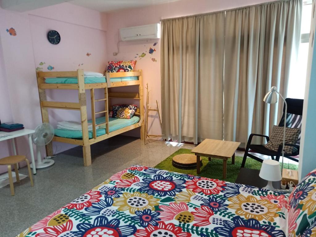 a bedroom with a bed and a bunk bed at Fish Hostel in Yingge