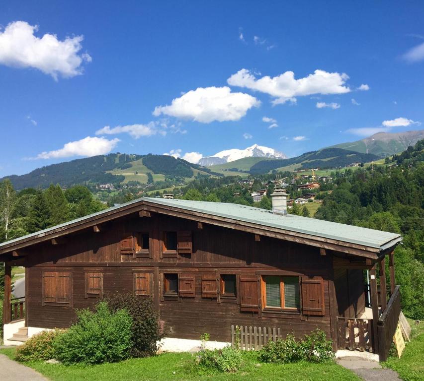 una casa de madera con montañas en el fondo en Close to the village - Chalet 4 Bedrooms, Mont-Blanc View en Megève