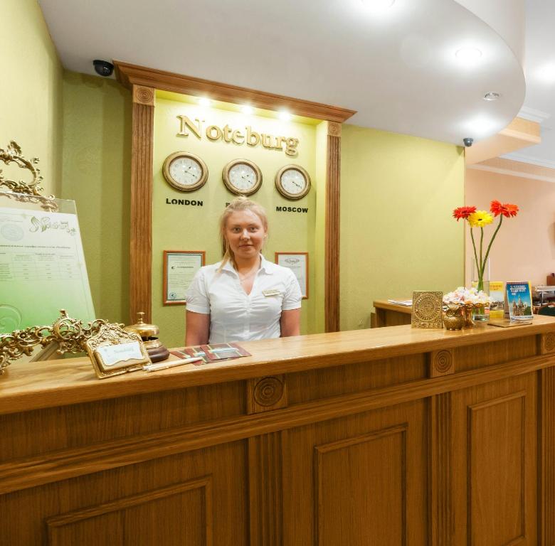 a woman is standing behind a reception desk at Noteburg in Saint Petersburg
