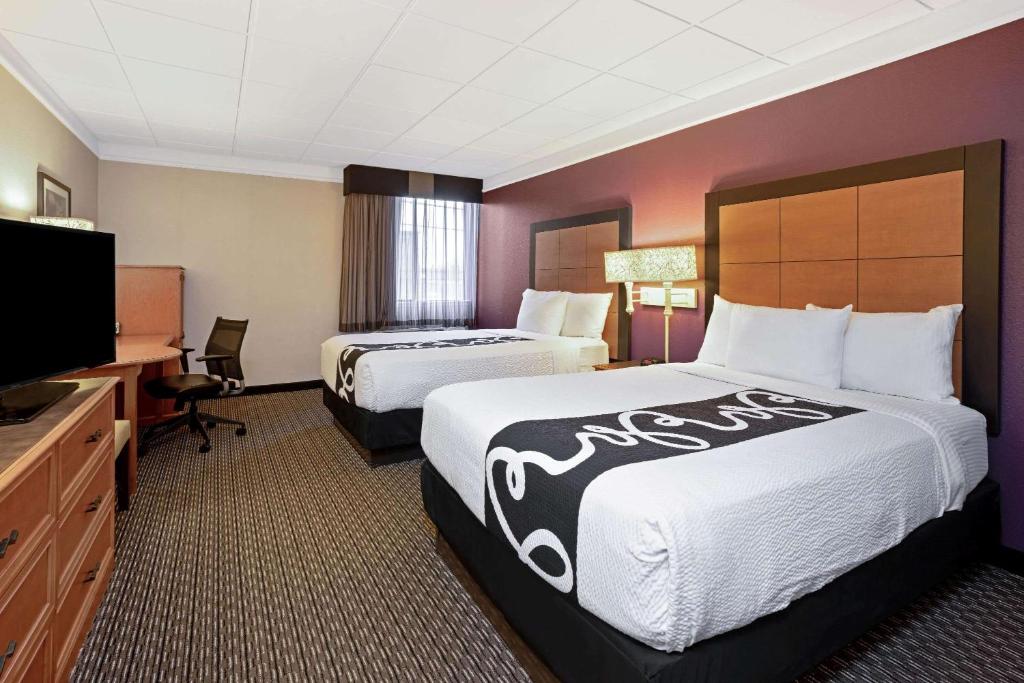 a hotel room with two beds and a flat screen tv at La Quinta by Wyndham Tacoma - Seattle in Tacoma