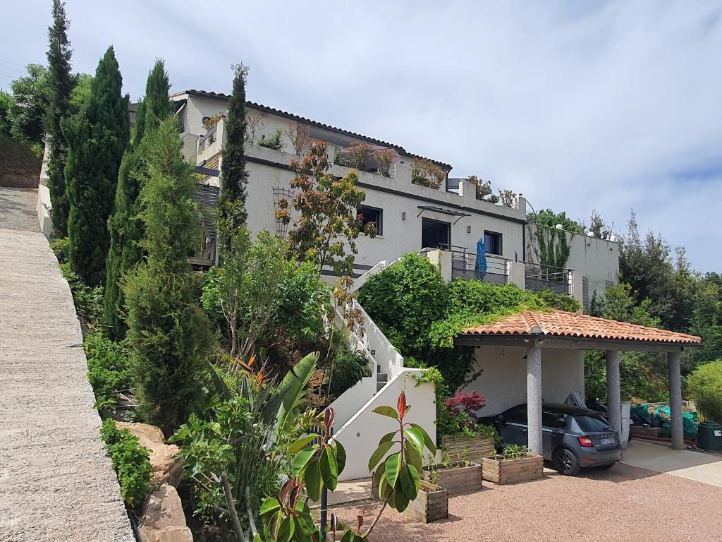 une grande maison blanche avec un escalier dans une cour dans l'établissement Appartement F2 avec terrasse de 35 m2 Bomorto - Porticcio, à Porticcio