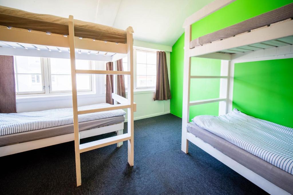 2 Etagenbetten in einem Zimmer mit grünen Wänden in der Unterkunft Tromso Activities Hostel in Tromsø