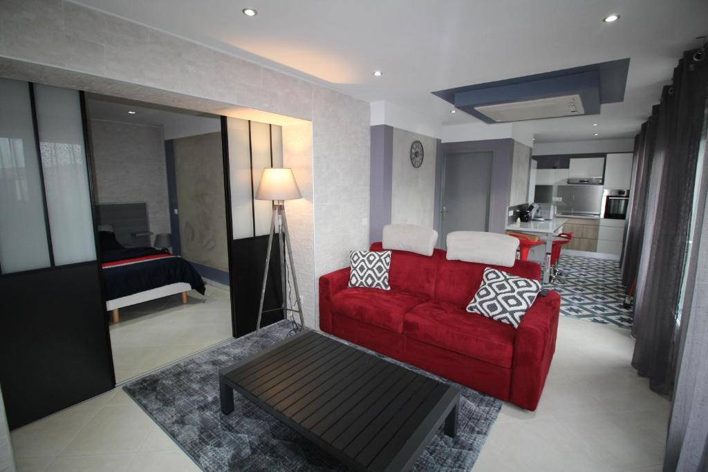 ein Wohnzimmer mit einem roten Sofa und einem Tisch in der Unterkunft Bel appartement 53 m2 in Ruy