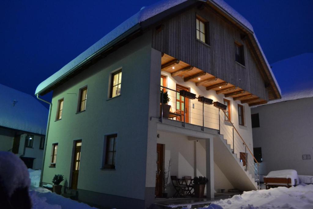 una casa nella neve di notte di Apartments Nac Bovec a Bovec