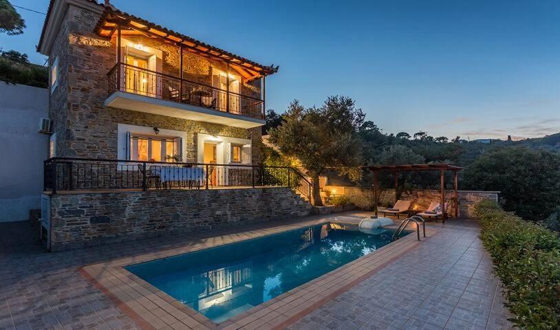 una casa con piscina frente a una casa en Villa alegria, en Skopelos Town