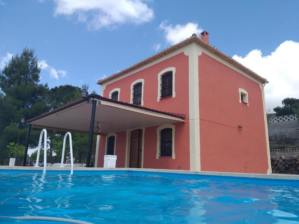 ein Haus mit einem Pool vor einem Gebäude in der Unterkunft Casita Roja. Alójate en la Sierra de Mariola. in Banyeres de Mariola