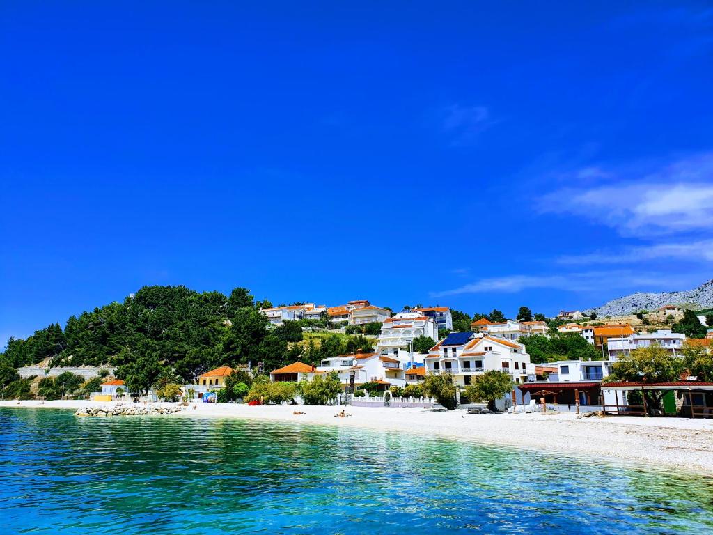 a view of a beach with houses and the water at Apartments Johnny in Podstrana